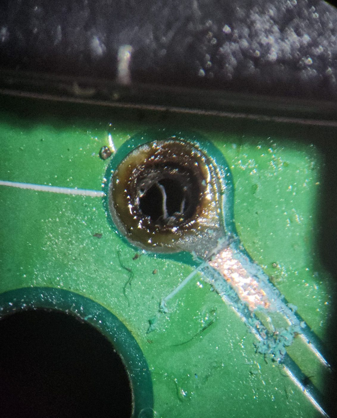 Broken plated-through hole under magnification